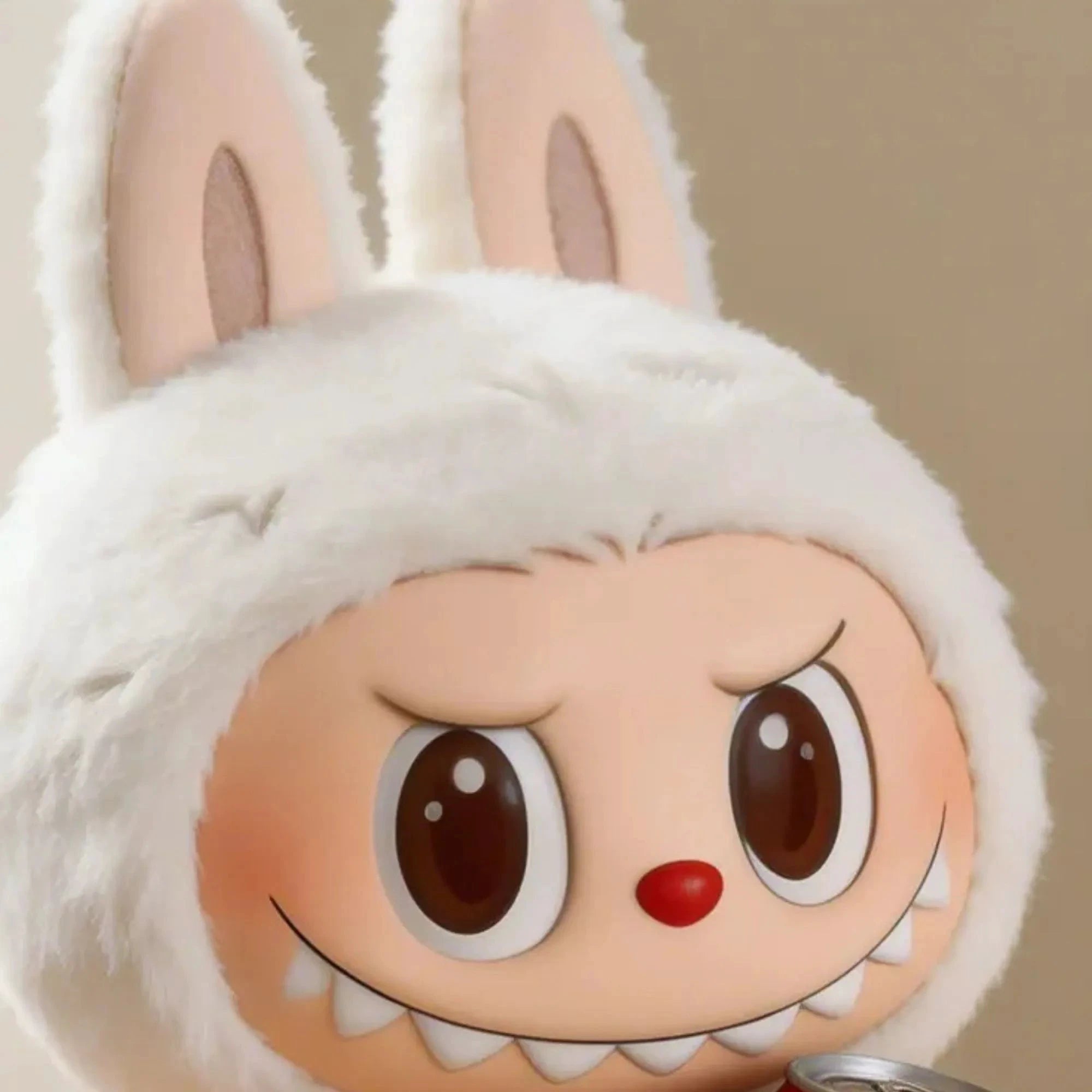 Gros plan détaillé sur le visage de la figurine de collection Labubu habillée en peluche de lapin blanc fluffy. La figurine a une expression malicieuse avec de grands yeux expressifs, des sourcils arqués, un nez rouge rond et une rangée de dents pointues visibles.