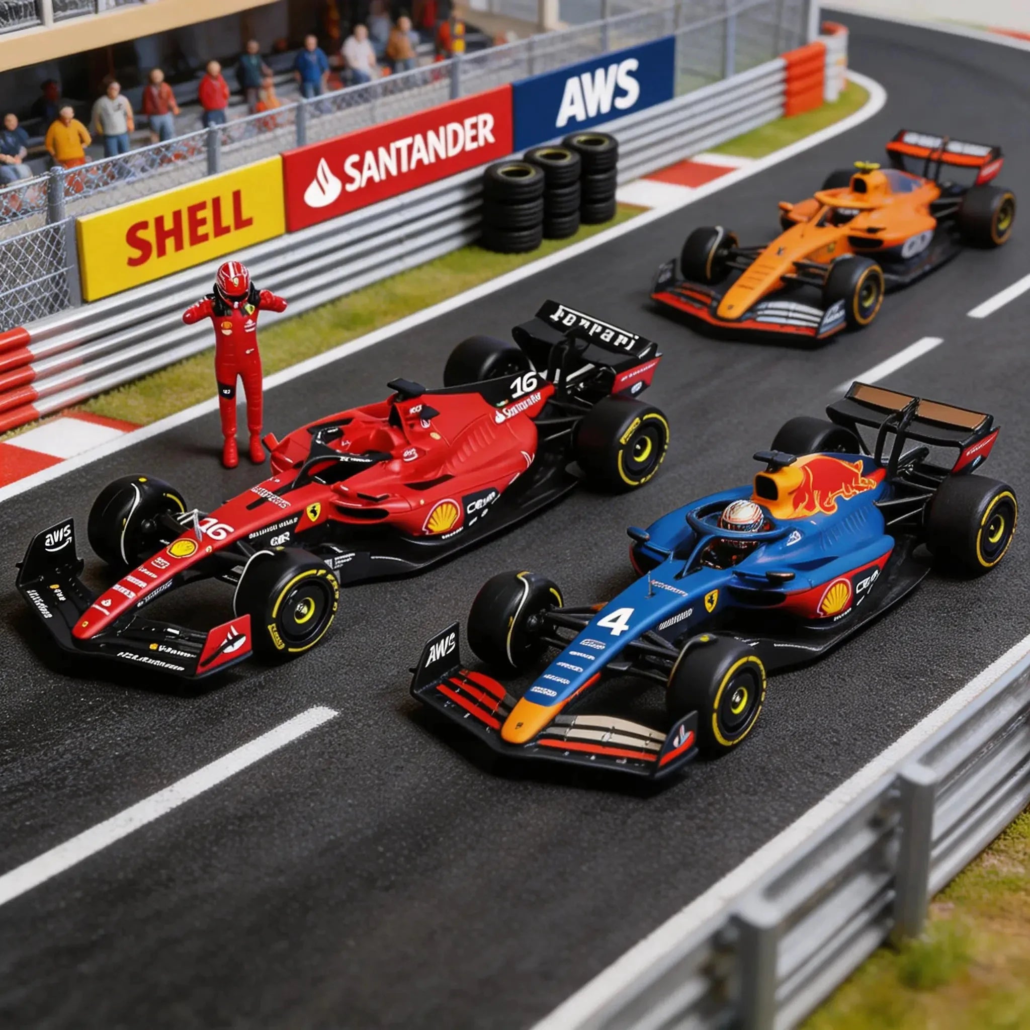 Un diorama de circuit de course en miniature montre trois voitures de Formule 1 à l'échelle : une Ferrari rouge numéro 16, une Red Bull bleue numéro 4 et une McLaren orange. Une figurine de pilote rouge se tient à côté de la Ferrari.